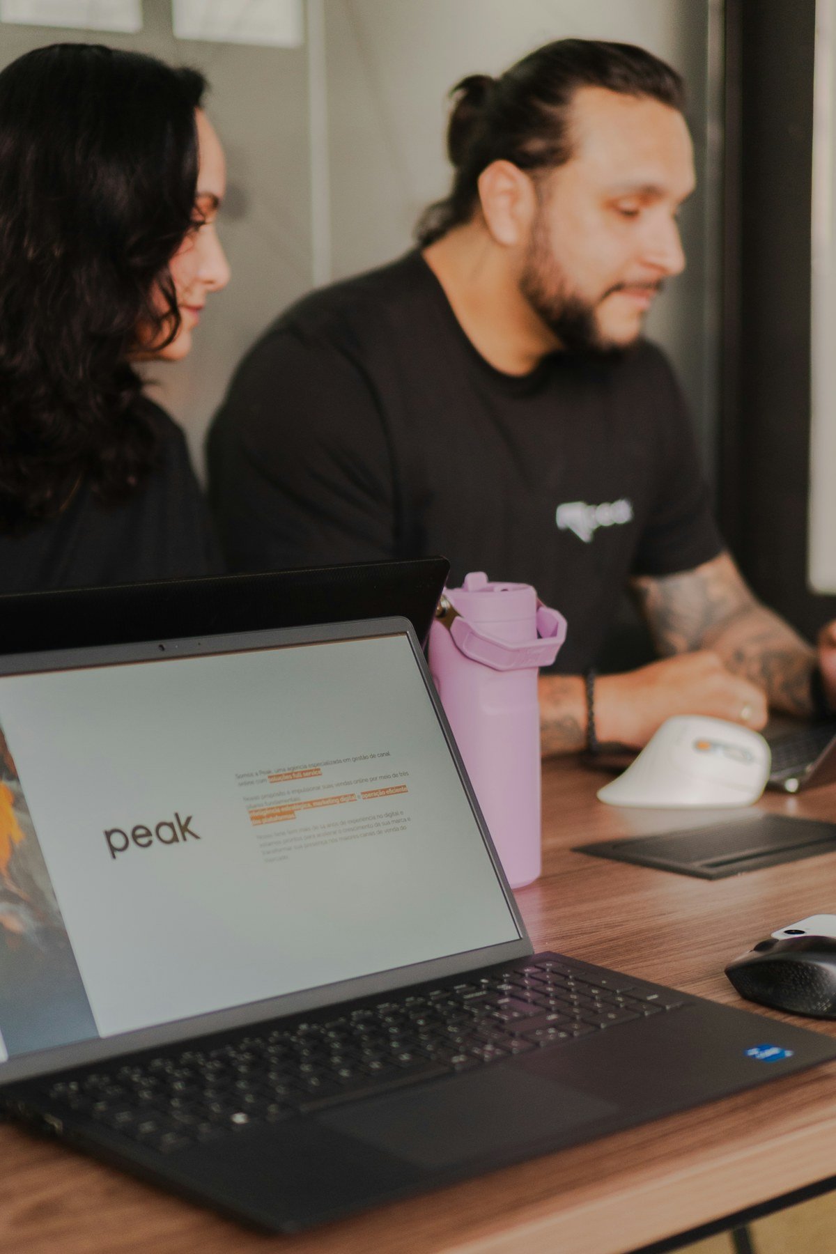 Two colleagues working together on laptops