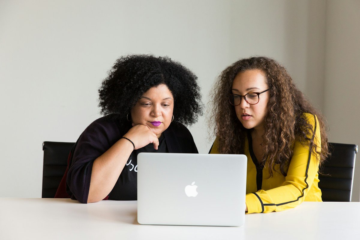 Two women reviewing work together on a laptop