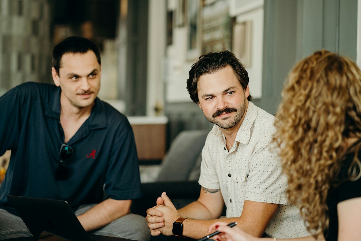 Three colleagues discussing a project over a laptop