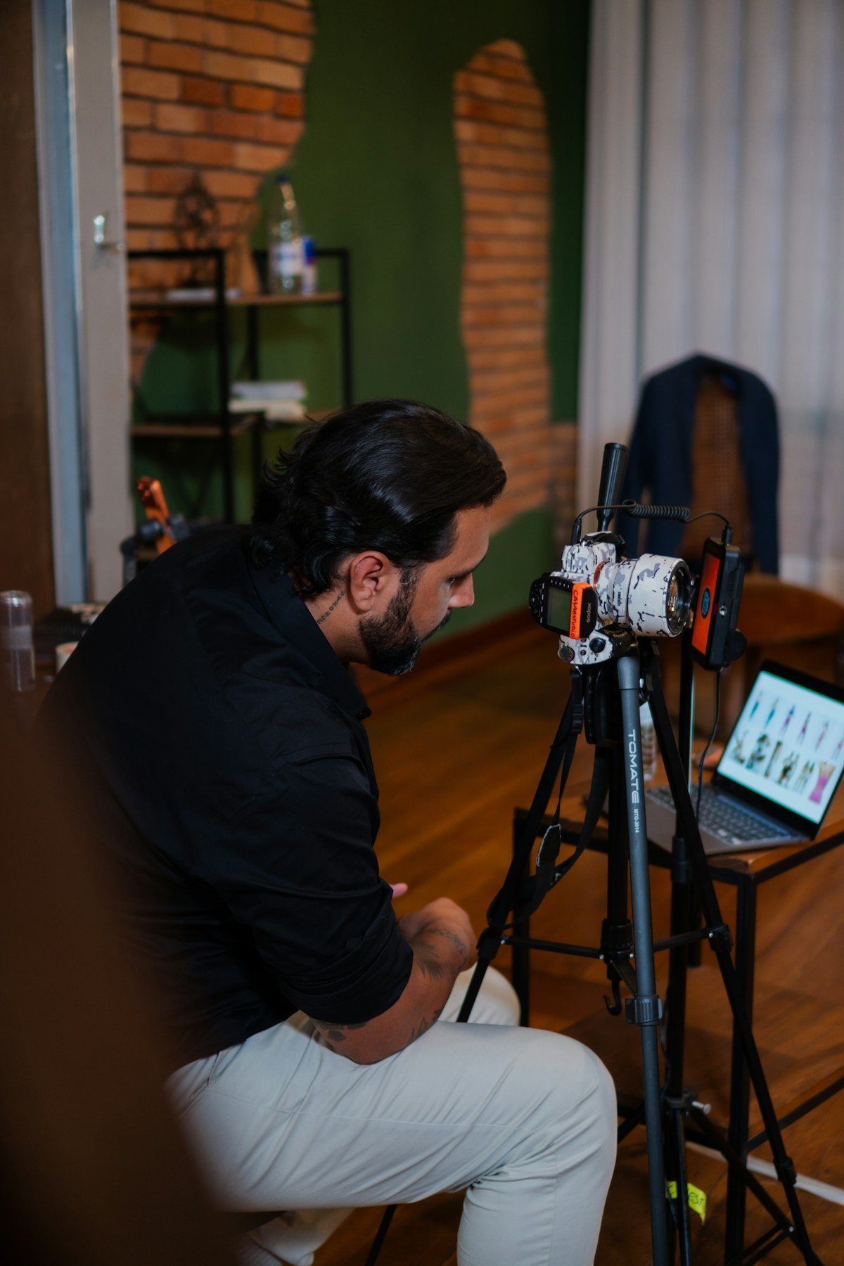 A filmmaker working with a camera setup and laptop