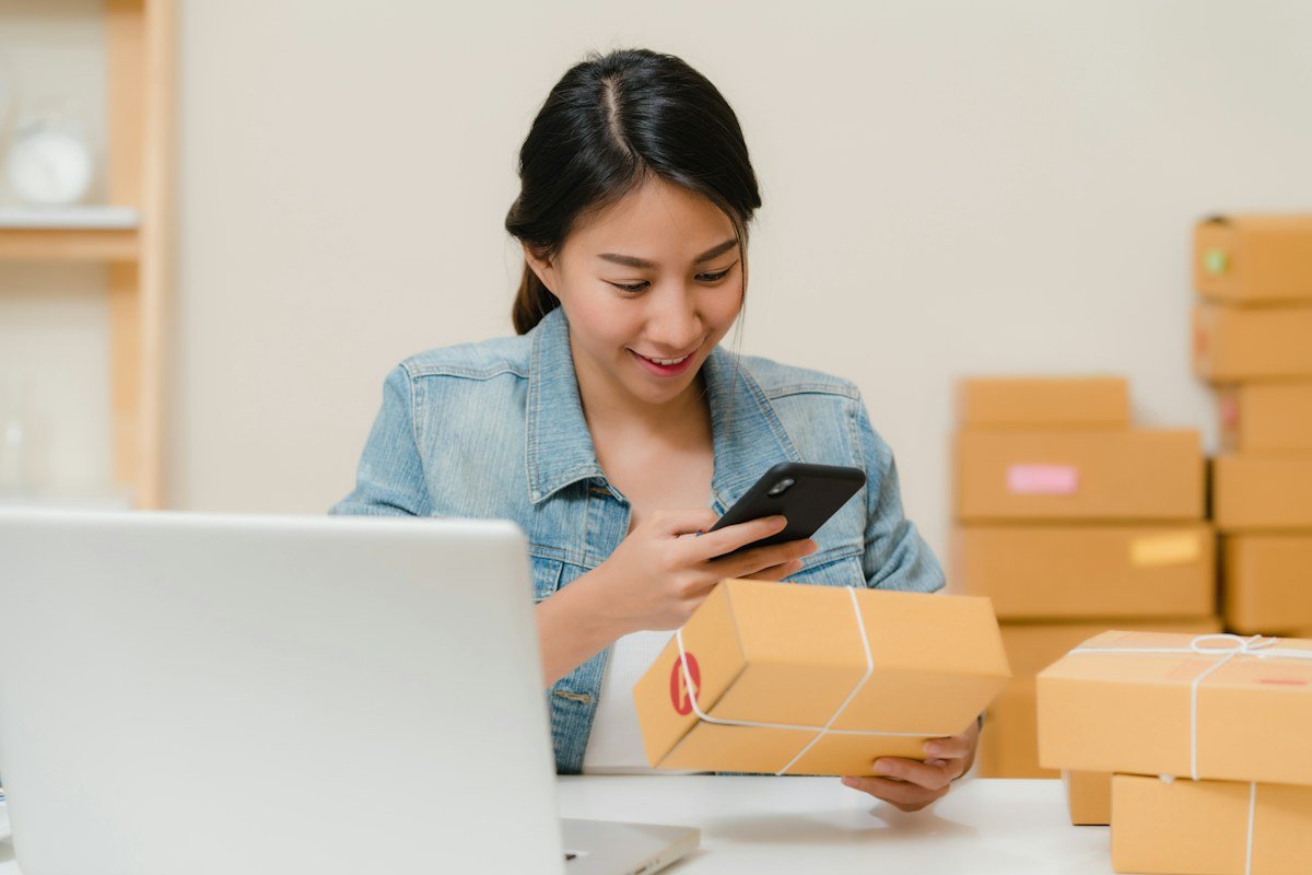 An online business owner checking a package beside her laptop