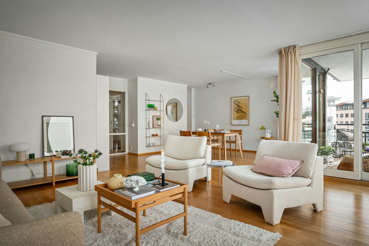 A real living room with cream seating, wood furniture and large windows